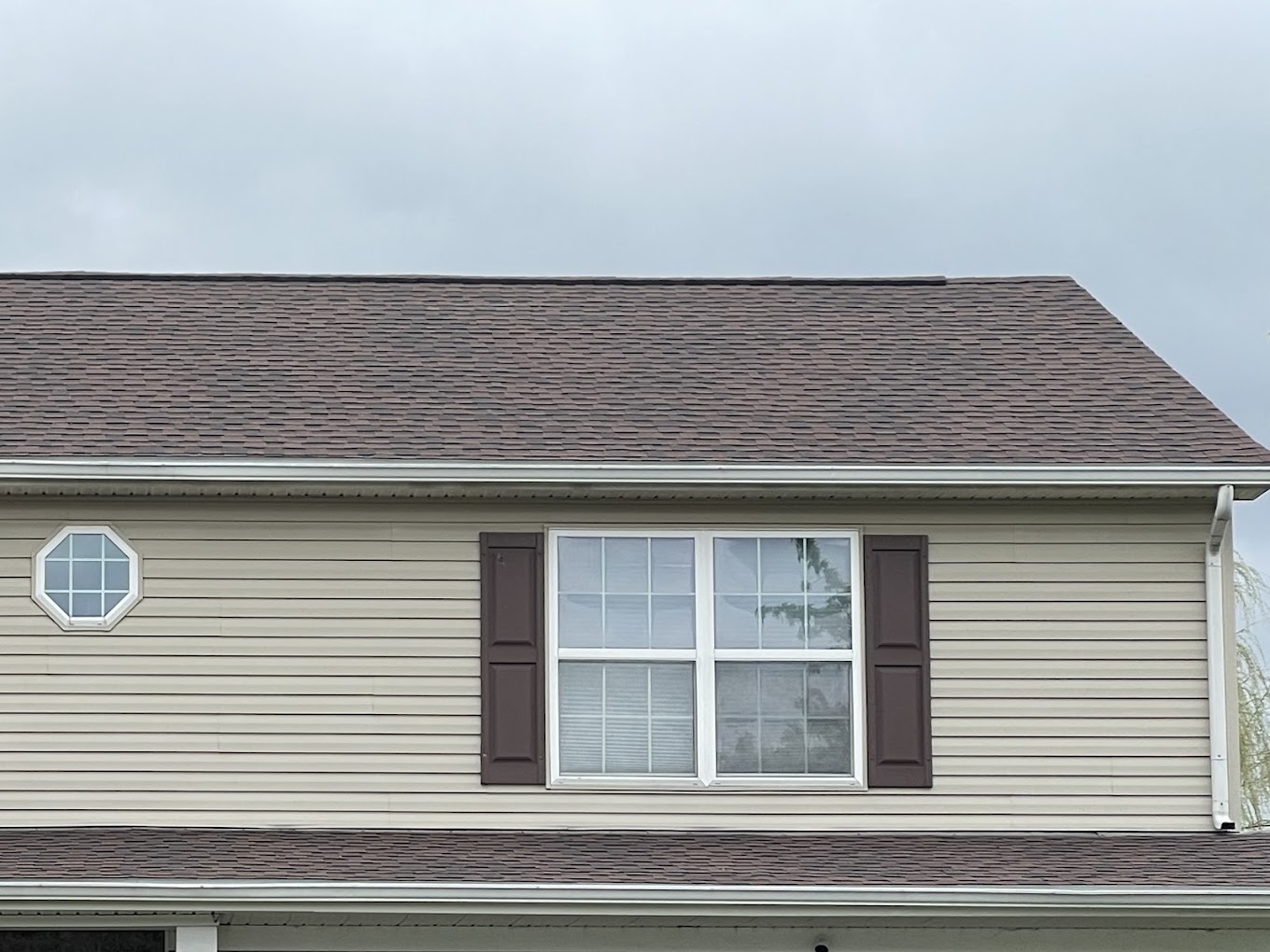 Roofer repairing step flashing where a chimney meets the shingles