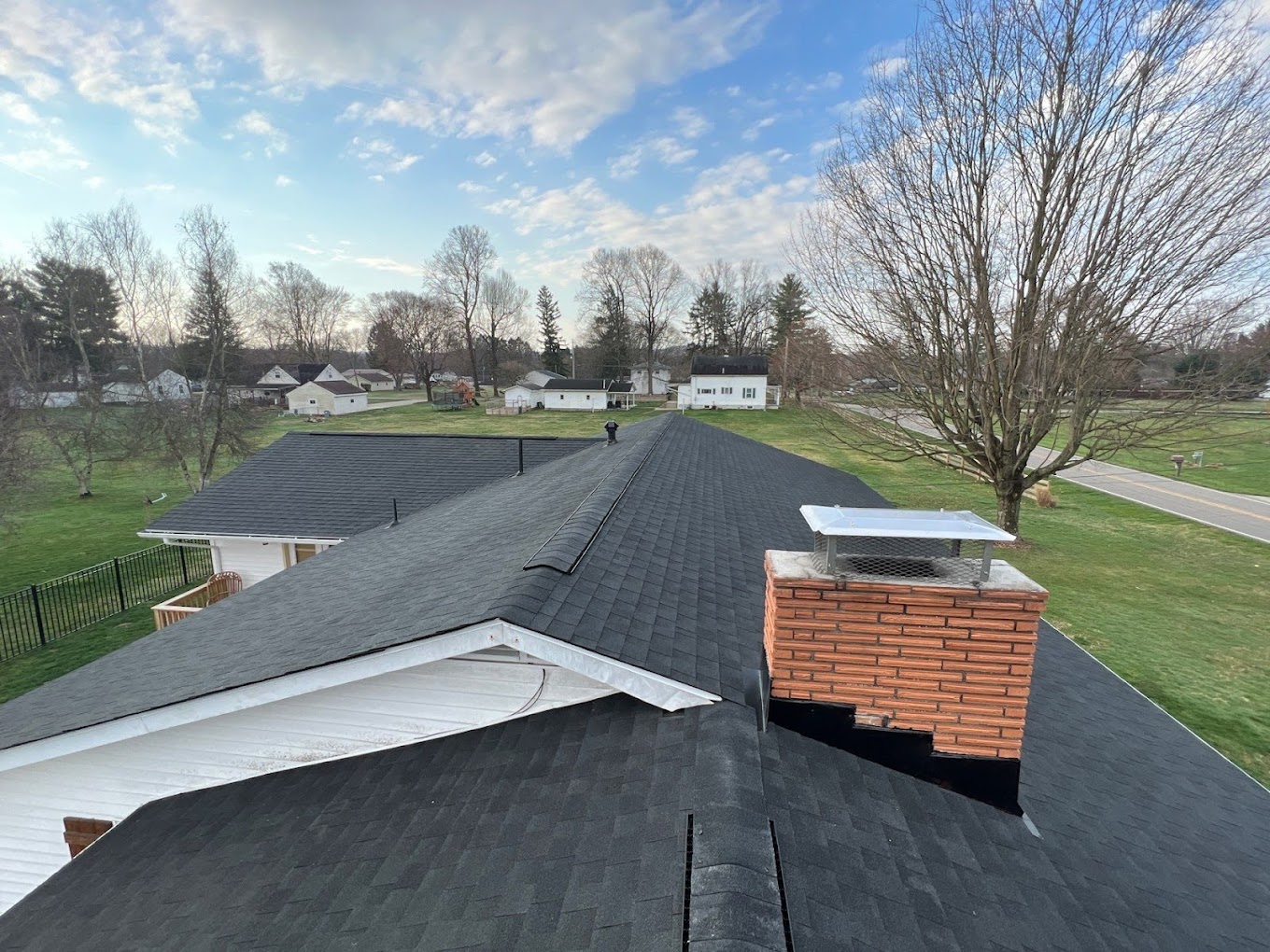 Roofing crew tearing off old shingles down to the deck on a Newark home